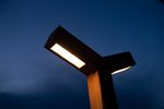 Een close-up van de zelfgemaakte parkeerplaats verlichting die aan is, met een donkere lucht op de achtergrond.