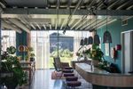 Het interieur van het Eemhuis met een bar, planten en grote ramen die uitzicht bieden op een tuin. De ruimte is licht en uitnodigend
