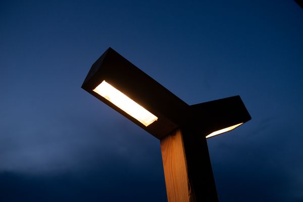 Een close-up van de zelfgemaakte parkeerplaats verlichting die aan is, met een donkere lucht op de achtergrond.